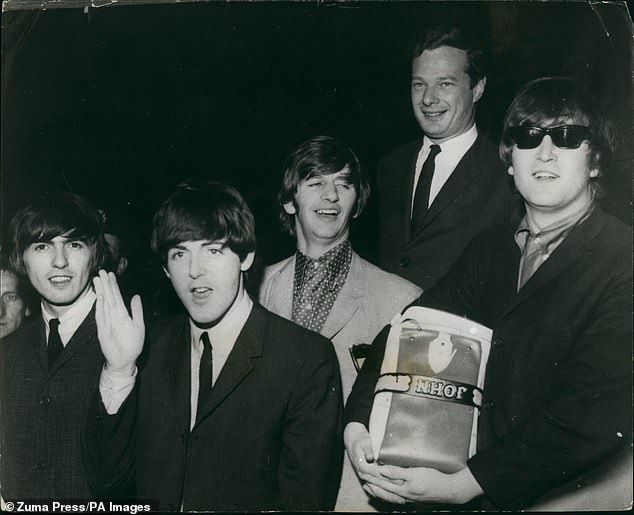 The group smiles as they pose with their manager Brian Epstein in the 1960s