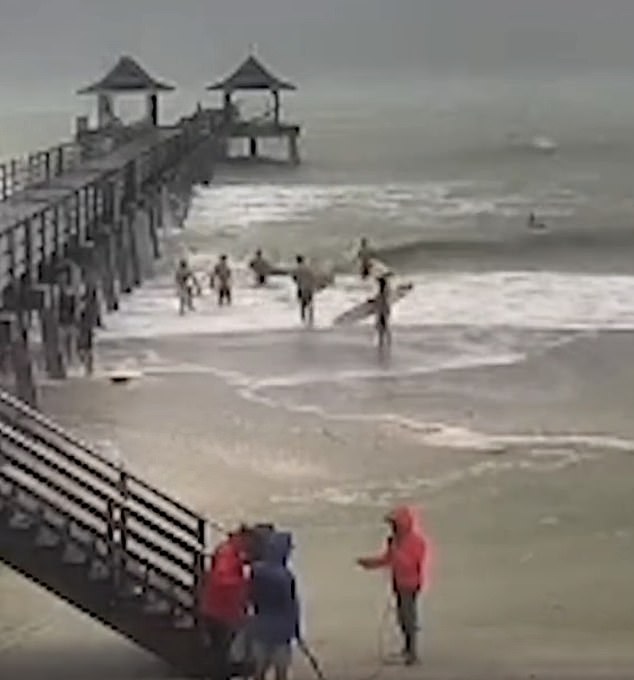 A group of surfers are seen riding the strong waves in Key West on Wednesday as Milton rolls in