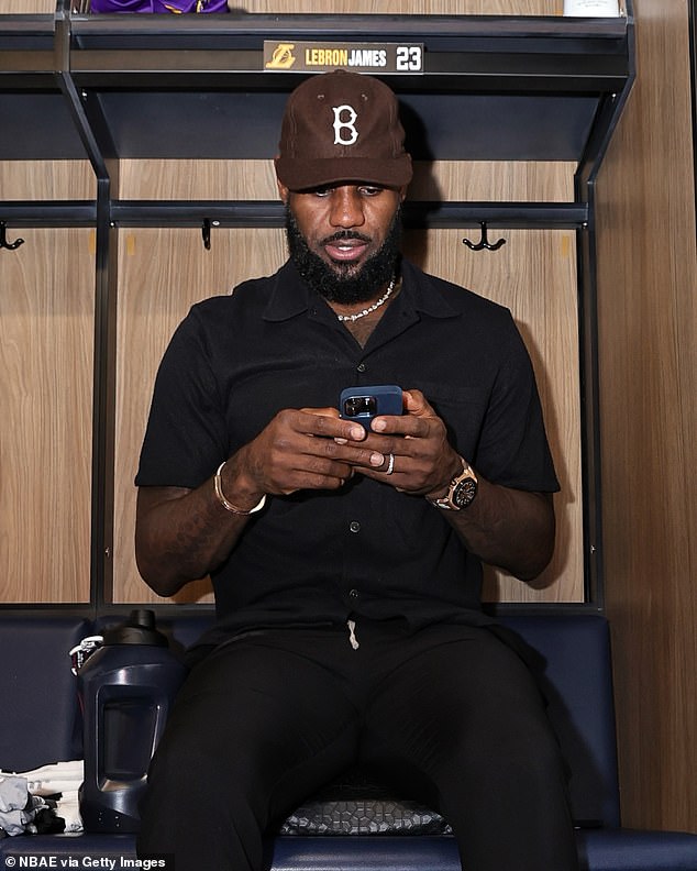 LeBron James is seen using his cell phone before a preseason game at Crypto.com Arena