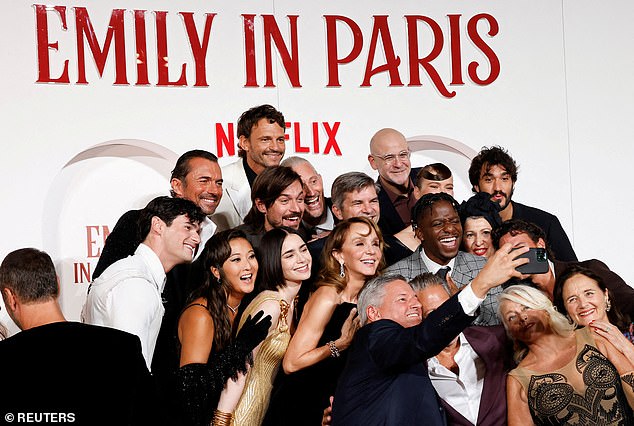 The cast of Emily in Paris poses for a selfie as they attend the European premiere of season four of the show