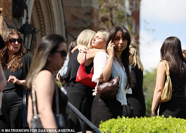 Mourners comfort each other outside St. Mark's Church