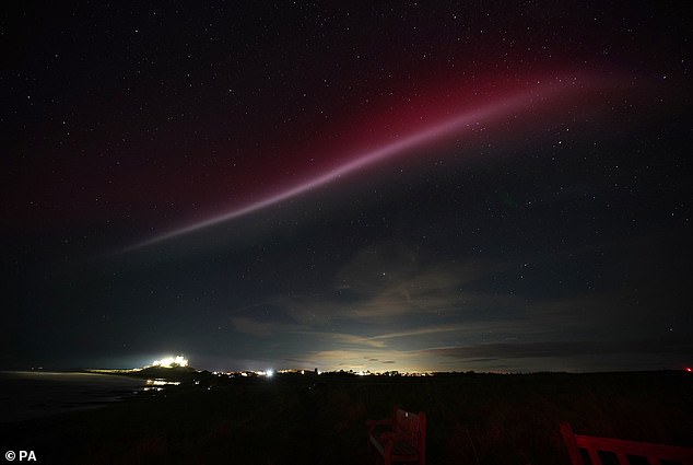 The atmospheric optical phenomenon is caused by a flowing ribbon of hot plasma breaking through Earth's ionosphere (pictured above Bamburgh Castle last year)