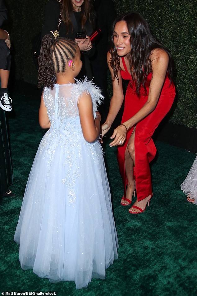 Meghan meets a young guest at the gala