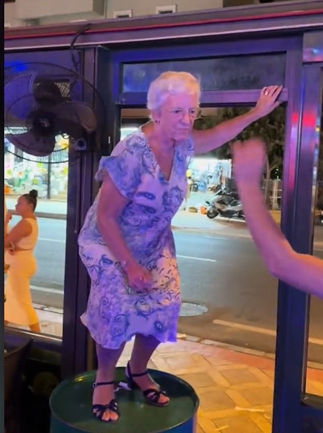 Wearing a loose floral dress and sensible black sandals, the cheerful pensioner steady herself by holding on to a window frame of the steak restaurant.