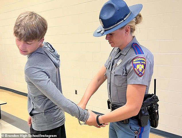 Williams, pictured with a recruiting driver at her local high school, claims the harassment continued until the day she was fired