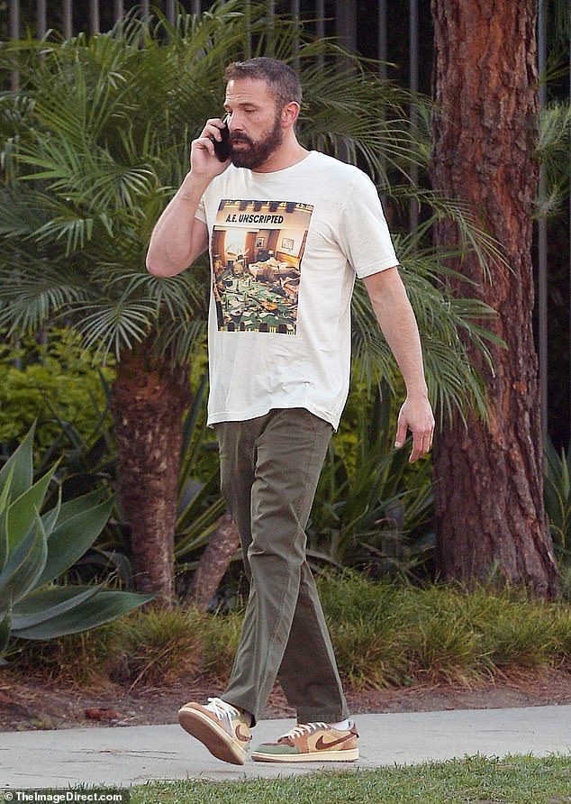 He looked casual in a white graphic T-shirt with slim olive trousers and a cool pair of green and brown Nike sneakers.