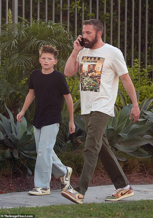 He was accompanied by his son Samuel, 12, as he took a phone call while sporting a tense expression