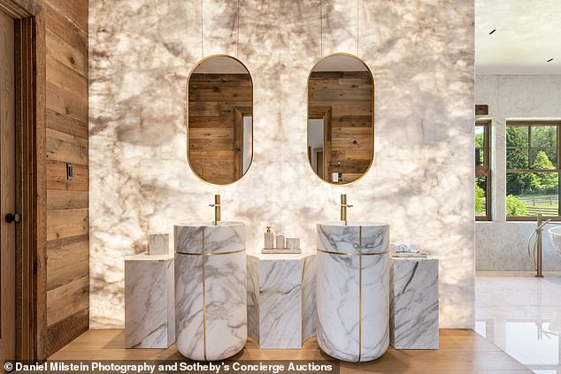 One of the bathrooms features a backlit white quartz vanity with his and hers sinks