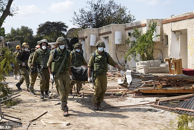 Israeli soldiers carry bodies of slain Israelis in Kibbutz Kfar Aza on Tuesday, October 10, 2023