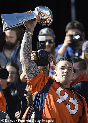 Derek Wolfe hoists the Super Bowl trophy on the steps of the City and County Building during the Denver Broncos Super Bowl championship celebration and parade on February 9, 2016