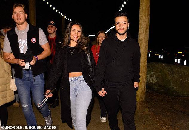 She paired a chic black coat with the ensemble and wore a pair of casual black and white sneakers