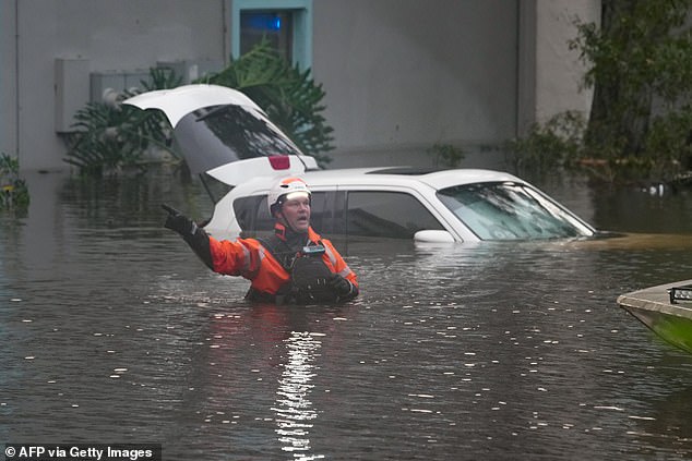 A first responder in the water outside a flooded apartment complex after Hurricane Milton on October 10, 2024 in Clearwater, Florida