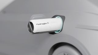 A hydrogen battery sticks out of the side of a gray car