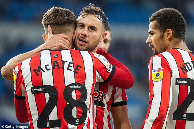 Baldock photographed (centre) hugging teammate McAtee in November 2022 as they played together for Sheffield United in the Championship