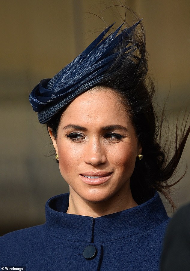 Meghan wore a navy blue coat and matching headpiece to Eugenie's wedding in 2018