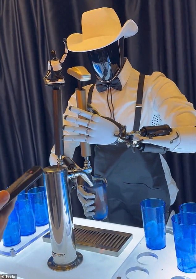 Tesla's bartending Optimus wore a cowboy hat, bow tie and suspenders as he served drinks to wide-eyed attendees