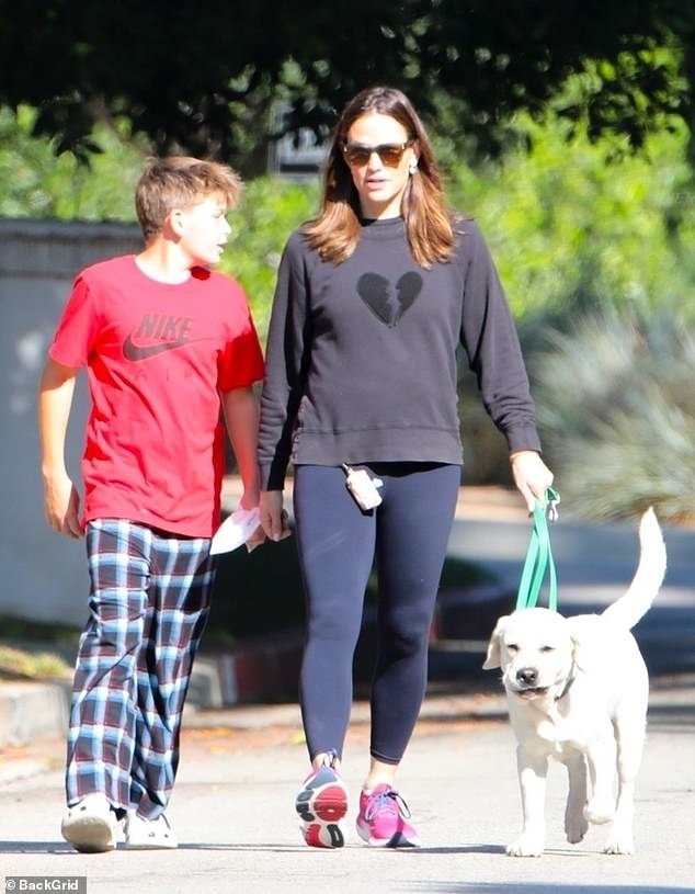 The mother of three kept it sporty in black leggings with a sweatshirt and sneakers as she led their dog on the route through their Brentwood neighborhood