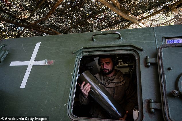 A Ukrainian soldier from the 30th Artillery Brigade checks the ammunition of 2S3 Akatsiya 152