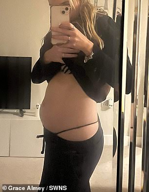 Grace takes a picture of her 'pregnant' looking belly