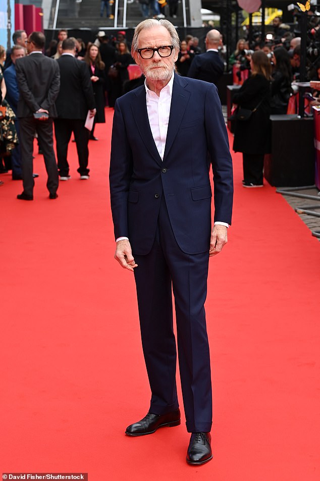 Love Actually star Bill, who plays Longneck in the film, cut a dapper figure in a navy blue suit which he teamed with a white open-collar shirt