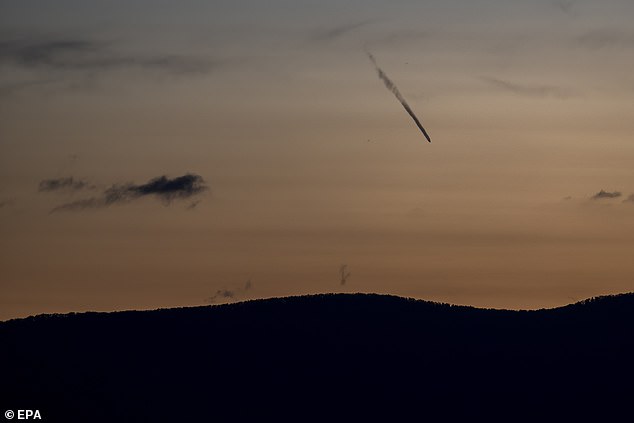 The comet looks like a dark streak in the Geneva sky here on Friday. It will not be seen again for 80,000 years as it leaves the vicinity of Earth