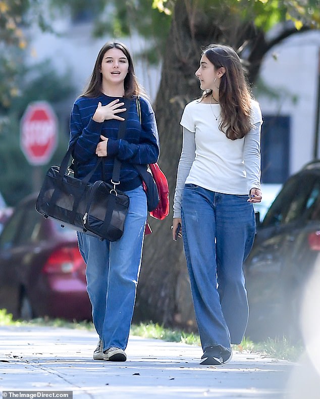 18-year-old Suri, who dropped dad Tom Cruise's surname for Noelle earlier this year, carried ragdoll cat Eleanor in a fabric carrier as she chatted with a friend during their walk