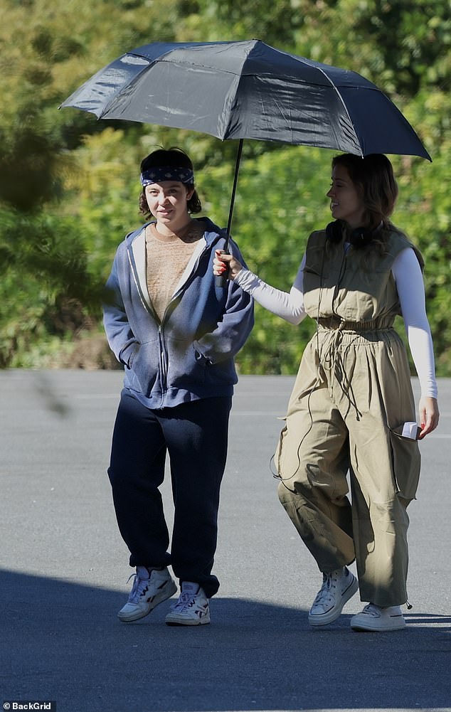 She covered up her famous curves in a brown shirt, blue hoodie and sweatpants and wore minimal makeup as she was escorted onto set.