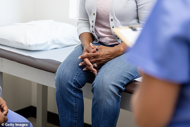 A woman folds her hands while talking to two medical personnel. Last year, women's health czar Dame Lesley Regan admitted that the NHS is “letting women down”.