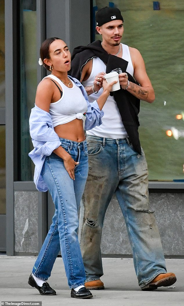 Footballer Romeo cut a casual figure during the outing, showing off his toned and tattooed arms in a white vest.