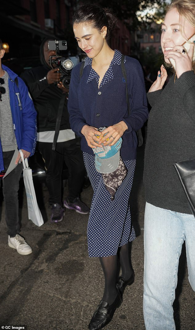 The Poor Things actress wore her dark hair tied in a messy bun, and she covered them up with black stockings as she completed her look with black loafers