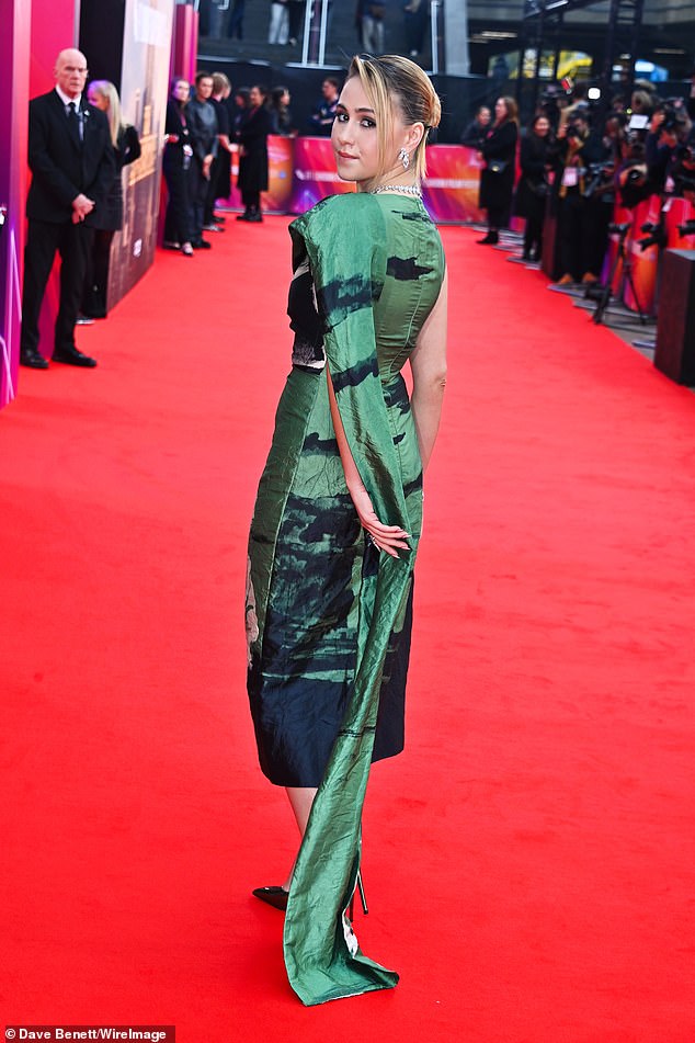 The elegant dress included an over-the-shoulder train and the star added a pair of metallic green shoes to her look