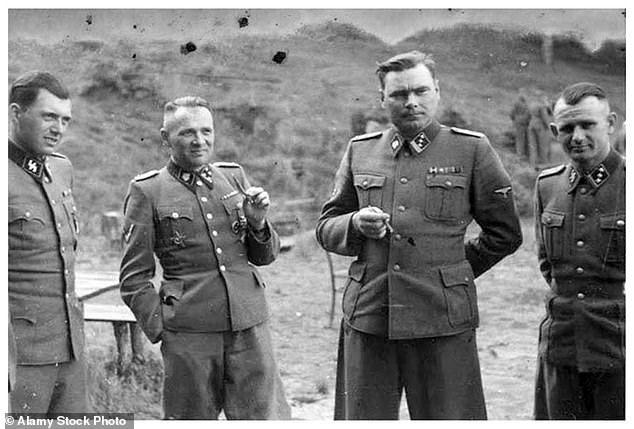 SS officers are pictured in front of a building during an SS retreat outside Auschwitz in 1944. From left to right; Josef Mengele, Josef Kramer, Rudolph Hess and Karl Hoecker