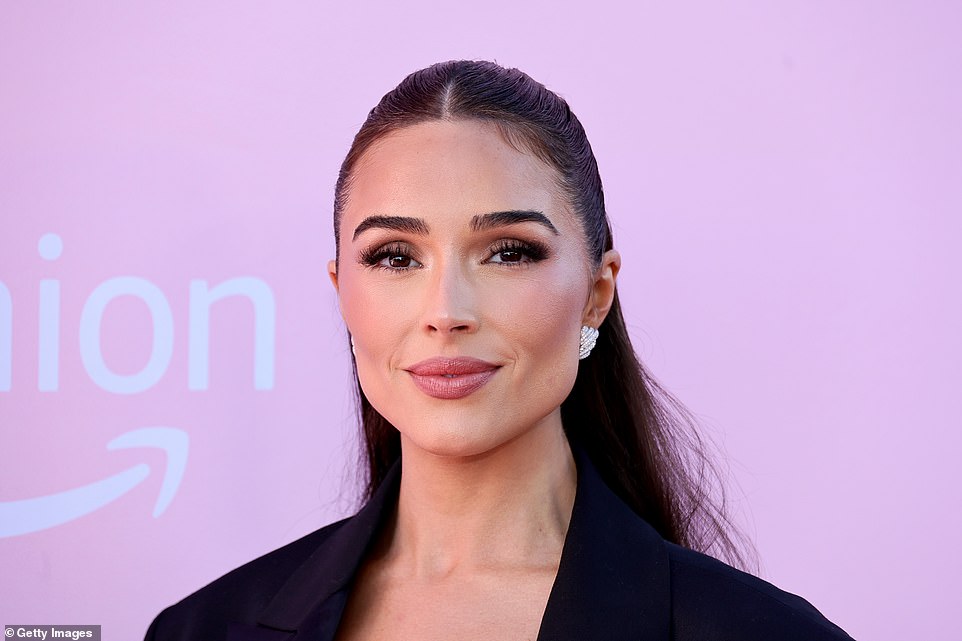 Olivia added some extra sparkle with diamond-encrusted earrings that she put in the spotlight by letting her long, center-parted hair hang straight down her back