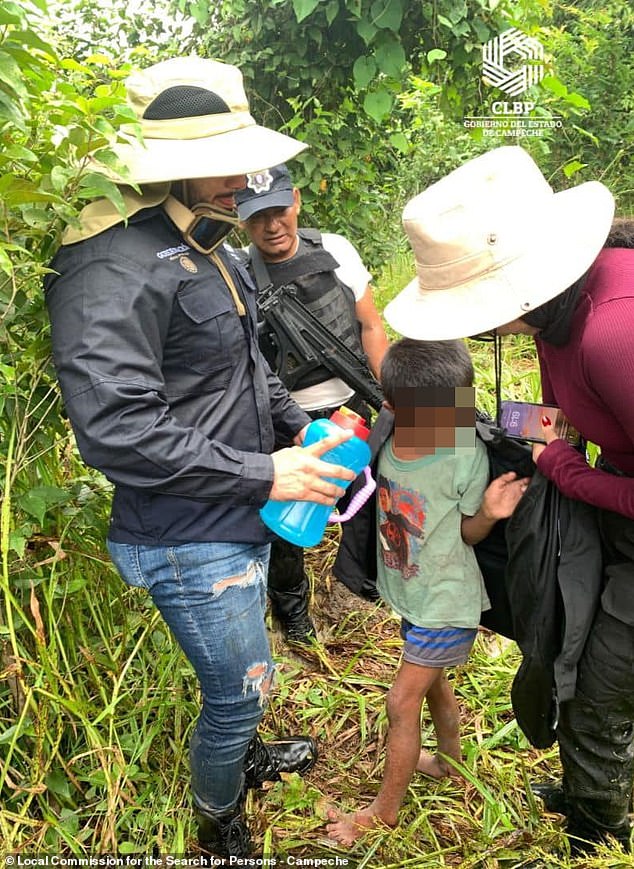 Rescue team workers provide Joel Acosta with water and a jacket after he was found near a cabin on Friday, six days after he ran away