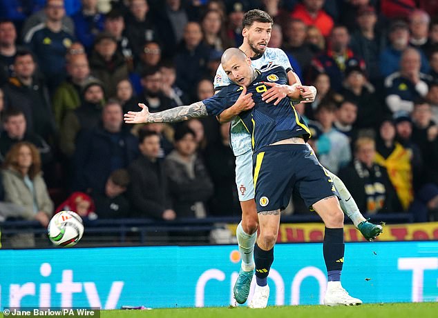 Ruben Dias keeps a close eye on Lyndon Dykes as the Scottish submarine wreaks havoc