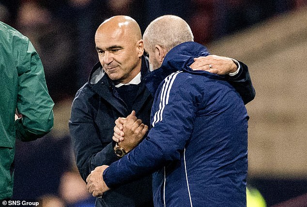 Managers Martinez and Clarke embrace at the end of the match