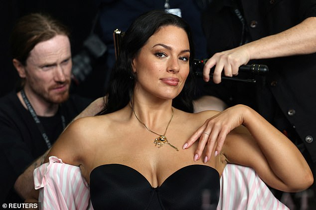 Plus-size model Ashley Graham looked sensational in a black strapless bra as her glam team put the finishing touches to her hair and make-up