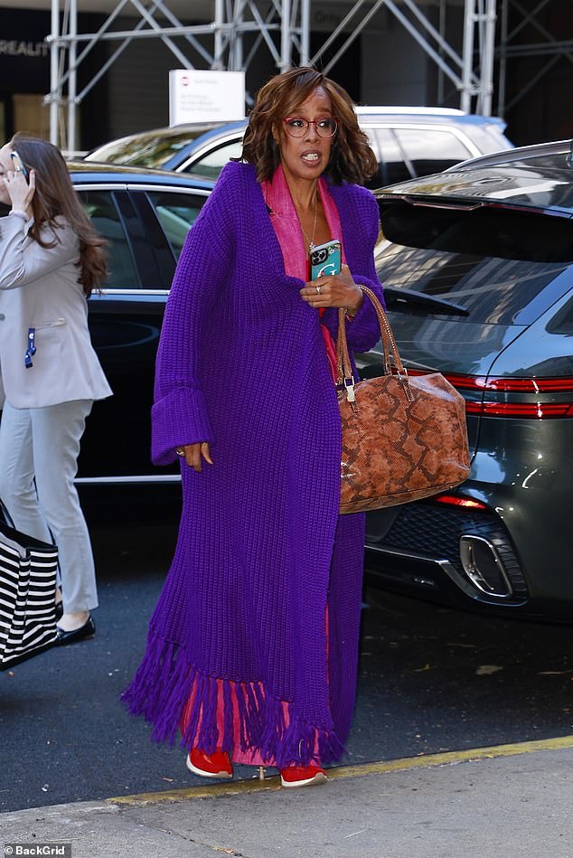 King, 69, dressed in a colorful ensemble with a purple knit cardigan, pink wide-leg trousers and red sneakers