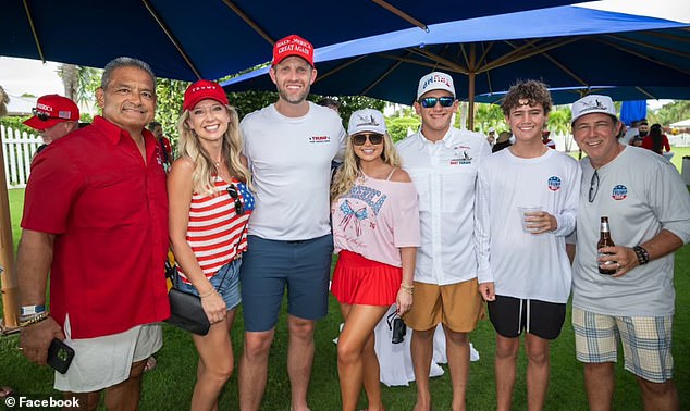 Carlos Gavidia (far left), the organizer of the boat parade, poses for a photo with other MAGA supporters, including Trump's son Eric (center)