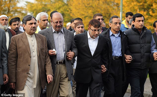 Dr. Abdul Shakoor (center) and members of the Muslim community follow the funeral procession to the crematorium after a prayer service in October 2012