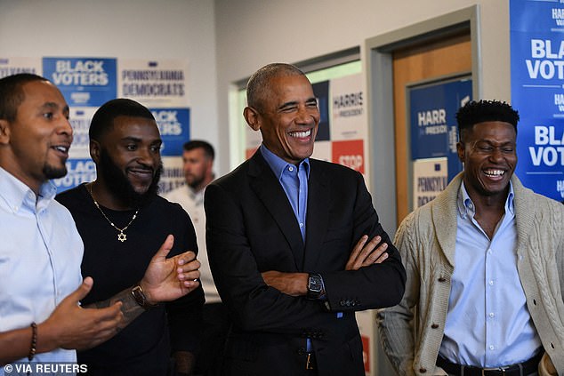 Former President Barack Obama laughs as he listens to an introduction at a campaign field office in Pennsylvania