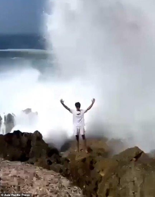 His friend posed with his arms in the air, oblivious to the incident happening behind him