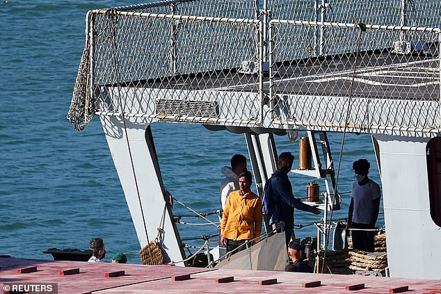 Migrants stand on the Italian navy ship Libra that arrived in Albania as part of a deal with Italy to process thousands of asylum seekers apprehended near Italian waters