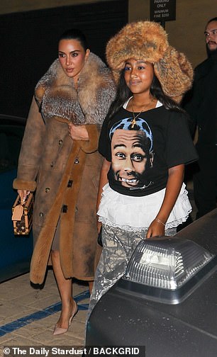 Kardashian wrapped the warm outerwear with a voluminous fur collar over what appeared to be taupe-colored biker shorts