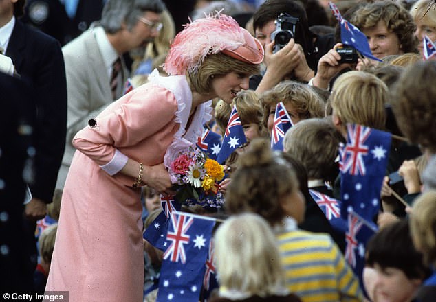 Diana, wearing a peach dress designed by Bellville Sassoon, is greeted by the crowd during a walk on March 25, 1983 in Canberra