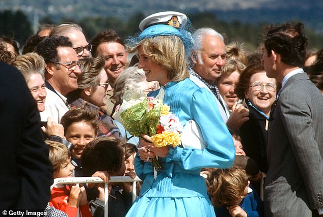 Diana holds flowers and talks to well-wishers with Charles as they arrive at RAAF Base Fairbairn in Canberra, Australia