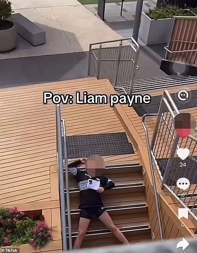 The video shows a girl running and pretending to jump off the edge of a balcony. Moments later, another student is seen on the ground of the lower level of the building