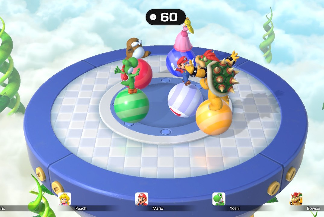 Characters from Super Mario Party Jamboree balance on balls that roll around on a circular platform