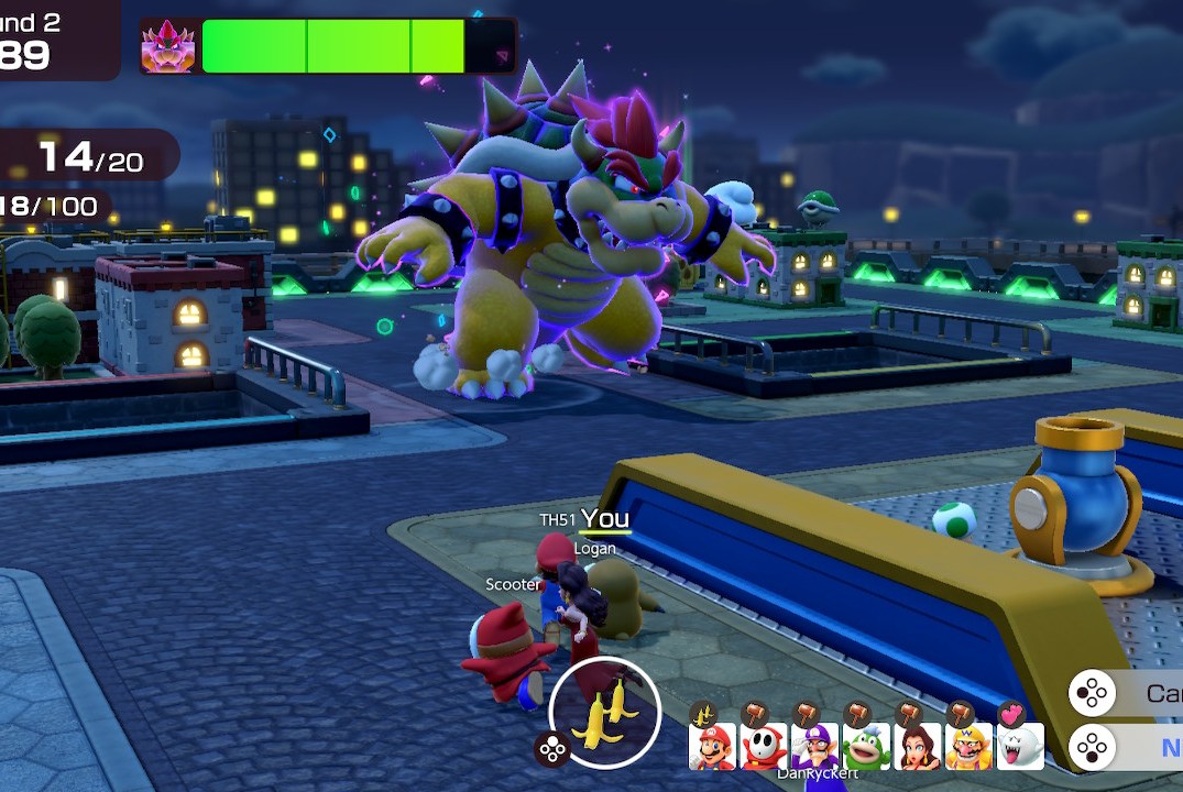 A screenshot from Super Mario Party Jamboree showing some of the game's characters hiding from a runaway Bowser on an urban rooftop