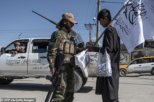 The Islamic Republic has said it aims to carry out two million deportations by March next year. Pictured: A Taliban security personnel talks to a flag seller outside the Eid Gah Mosque in Kabul on April 20, 2023